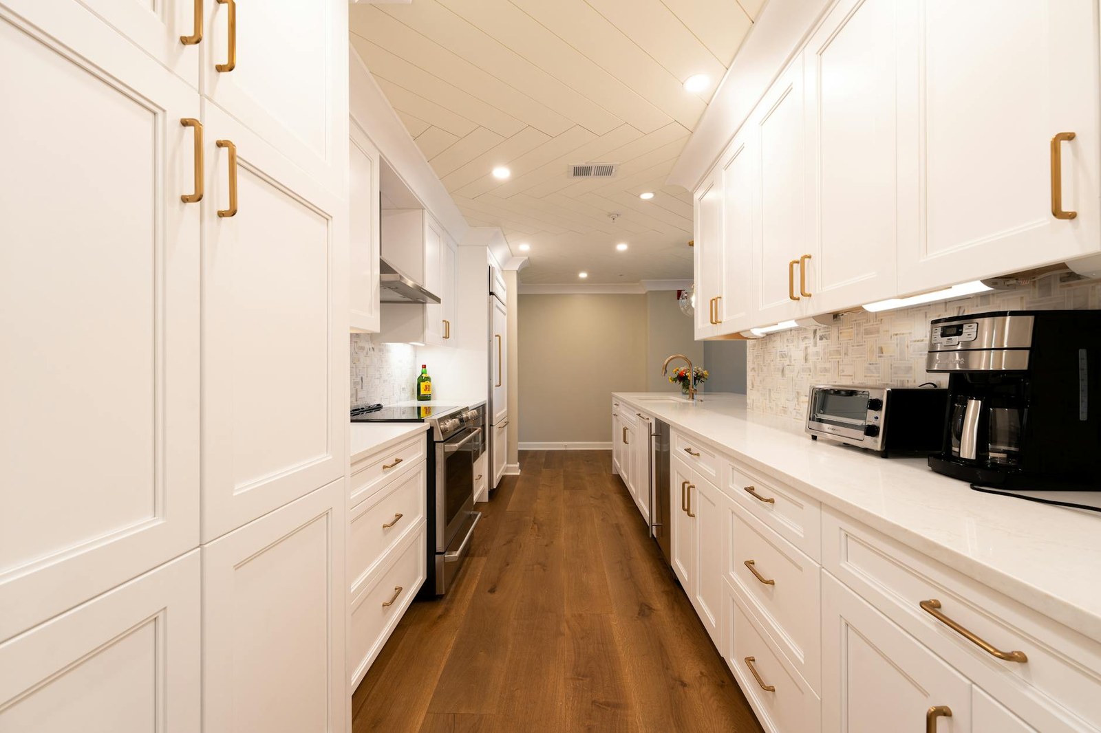 Compact galley kitchen renovation in an Adelaide townhouse with pull-out pantry and stone benchtop