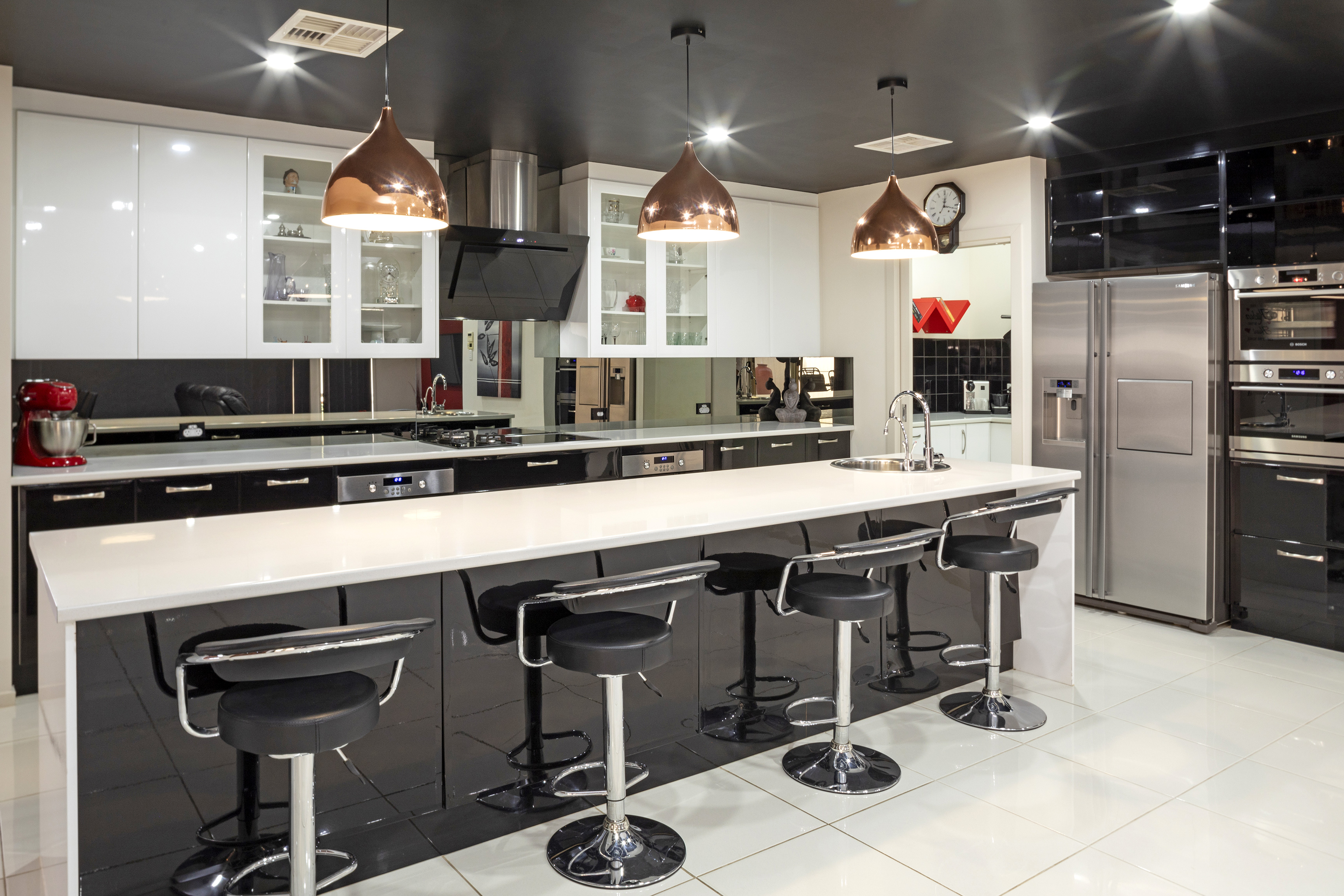 Walnut and cream Adelaide kitchen with stone island bench and brass tapware in golden-hour daylight