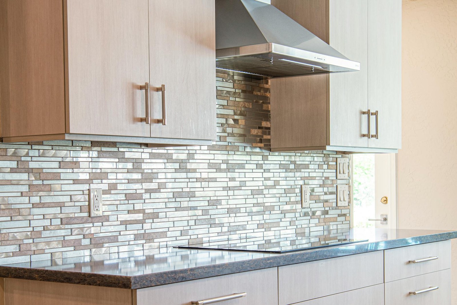 Three kitchen splashback styles — glass, herringbone tile, and stone — in Adelaide kitchens