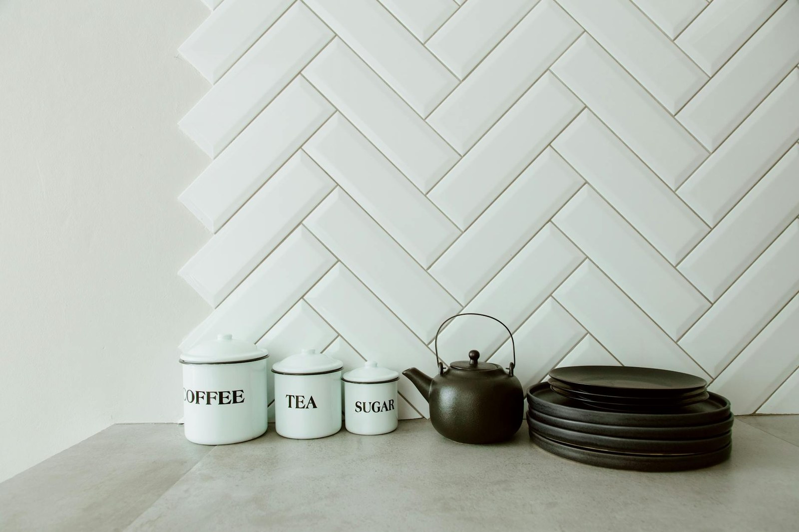 Three Adelaide kitchen splashback styles — herringbone tile, full-height stone and coloured glass — shown side by side